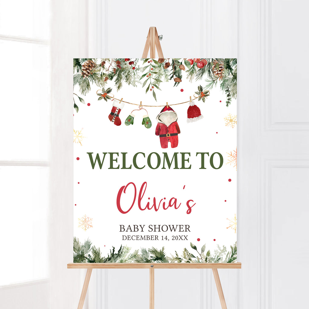 Festive Christmas baby shower welcome sign with Santa baby theme and holiday greenery decoration