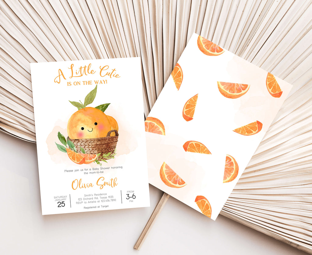 Baby shower invitation with orange design and matching paper on a neutral background