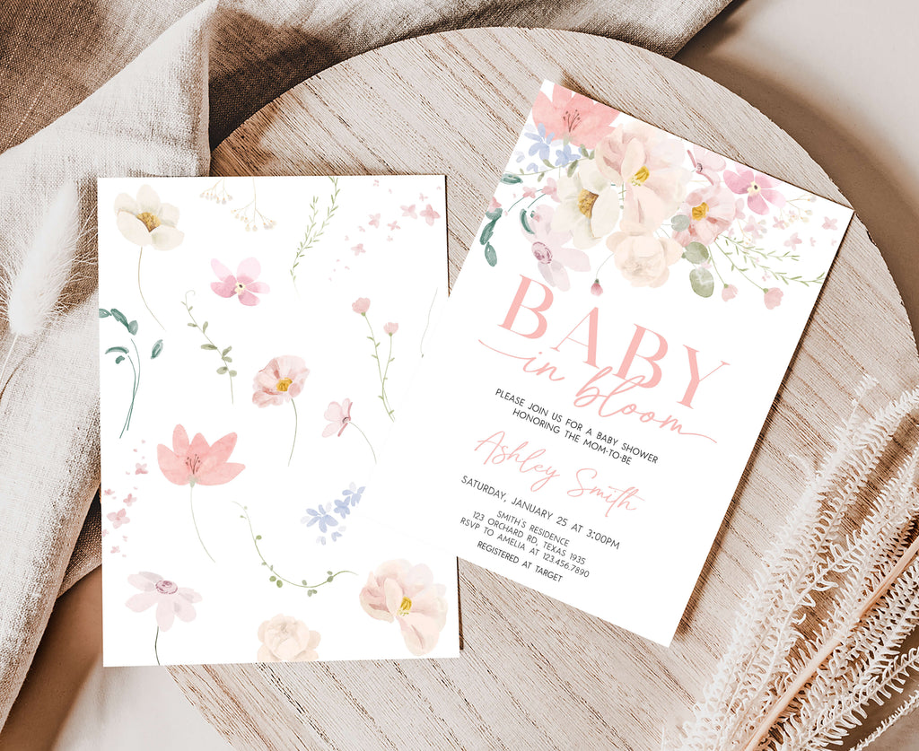 Floral baby shower invitation on a wooden surface