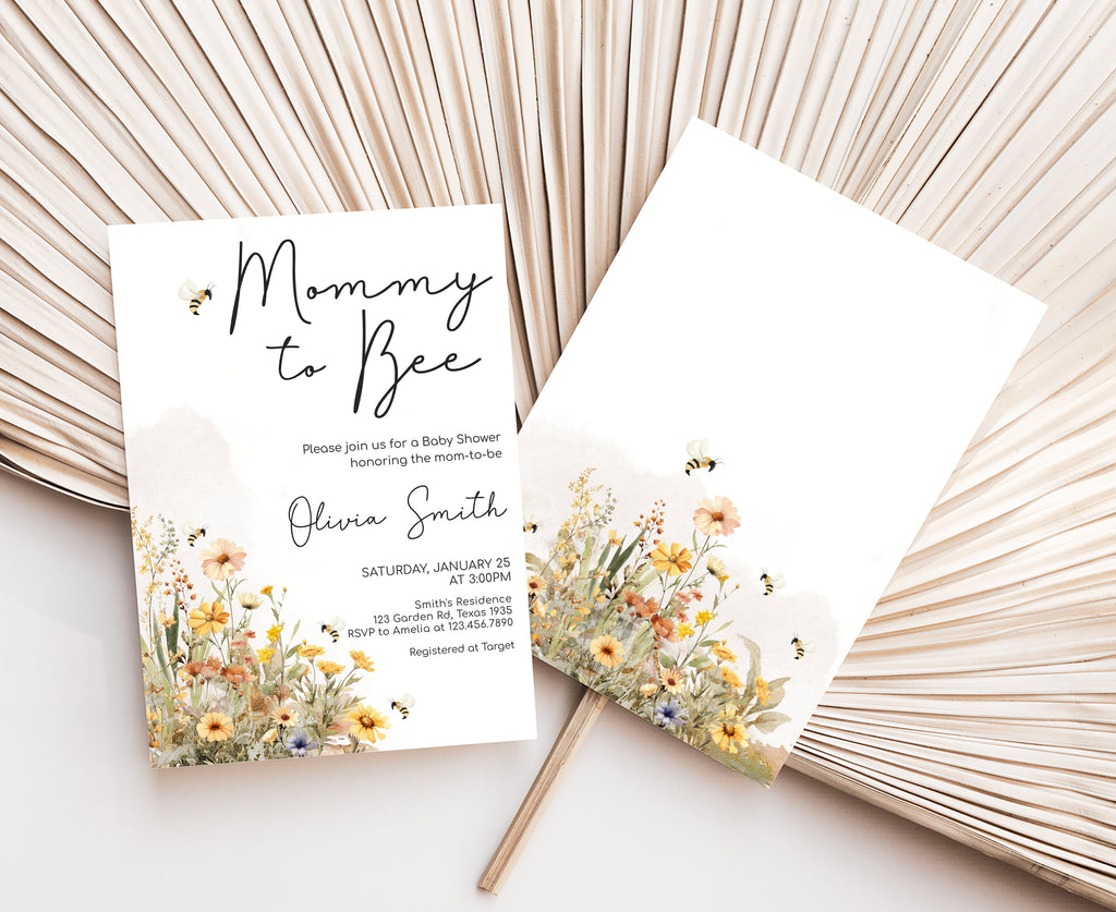 Baby shower invitation with floral design and 'Mommy to Bee' text on a white surface.