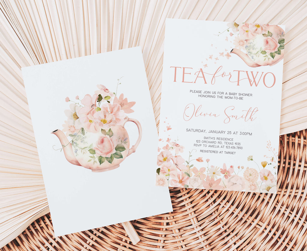 Two floral tea-themed baby shower invitations on a woven surface